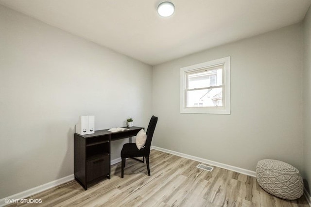 office area featuring visible vents, light wood-style floors, and baseboards