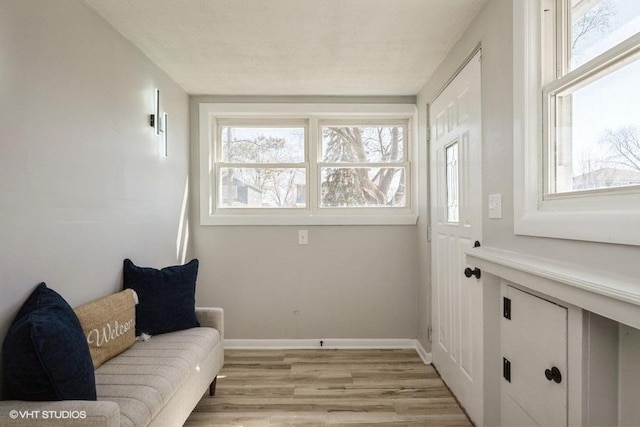 sitting room featuring baseboards and light wood finished floors