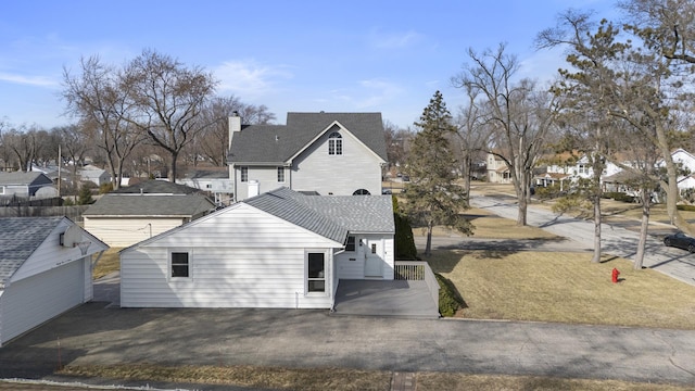 view of home's exterior featuring a yard, a residential view, and roof with shingles