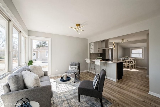 living room featuring baseboards, plenty of natural light, dark wood-type flooring, and ceiling fan