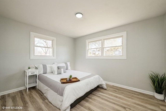 bedroom featuring baseboards and light wood finished floors