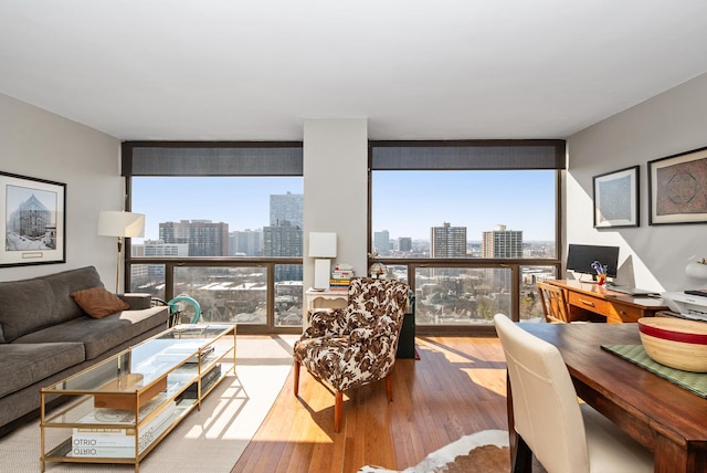 living area featuring a wall of windows, plenty of natural light, and wood finished floors