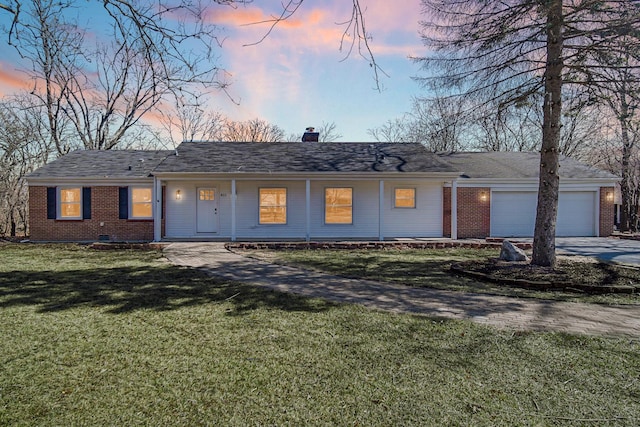 single story home with brick siding, a front lawn, a chimney, driveway, and an attached garage