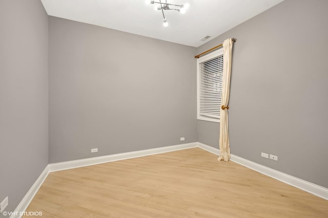 empty room with visible vents, baseboards, and light wood-style floors