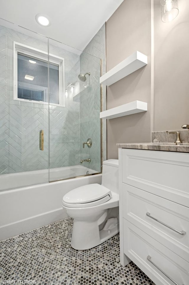 full bathroom featuring vanity, toilet, tile patterned flooring, and enclosed tub / shower combo