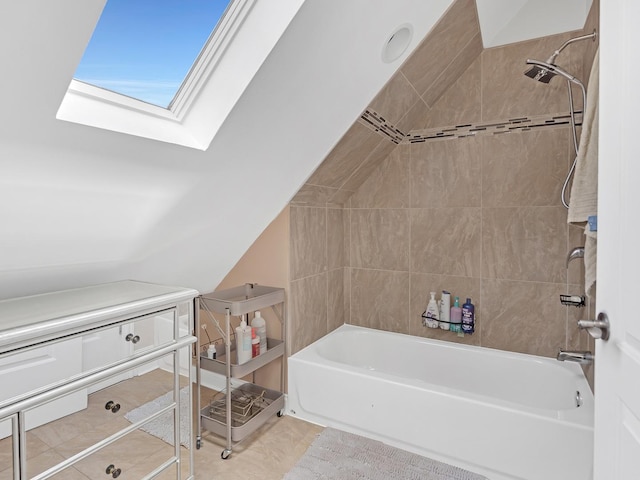 bathroom with vaulted ceiling with skylight, shower / washtub combination, and tile patterned floors