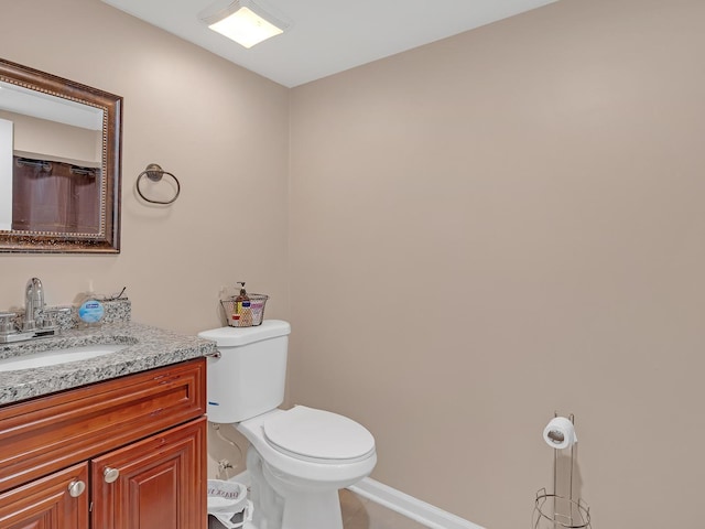 full bath with baseboards, toilet, and vanity