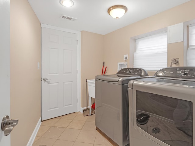 washroom featuring visible vents, independent washer and dryer, light tile patterned flooring, baseboards, and laundry area