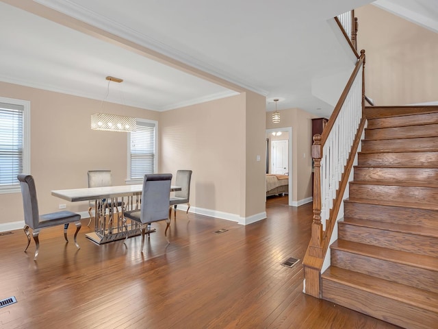 dining space with visible vents, ornamental molding, stairs, and wood-type flooring