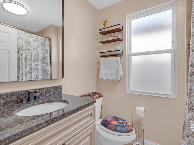 bathroom with curtained shower, toilet, and vanity