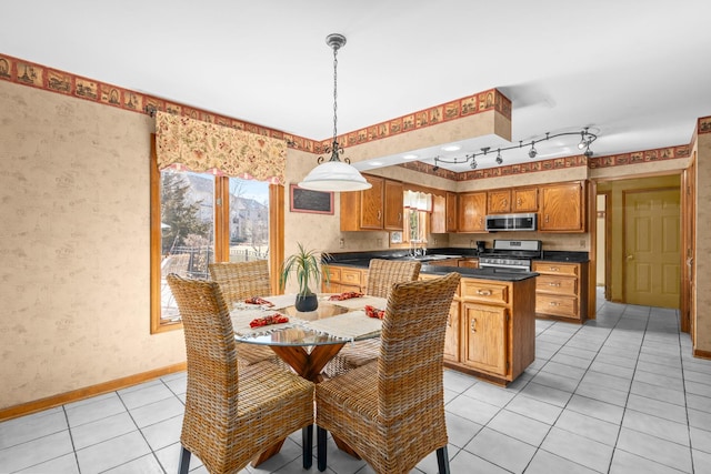 dining space featuring light tile patterned floors, wallpapered walls, and baseboards