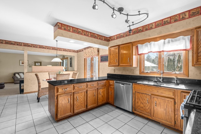 kitchen with range with gas stovetop, brown cabinetry, a peninsula, a sink, and dishwasher