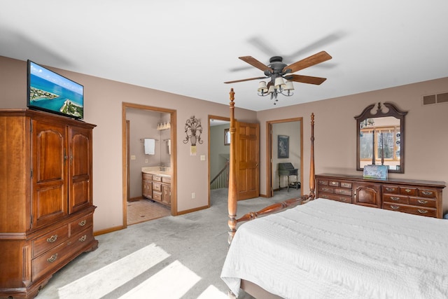 bedroom featuring baseboards, visible vents, ceiling fan, ensuite bathroom, and light carpet