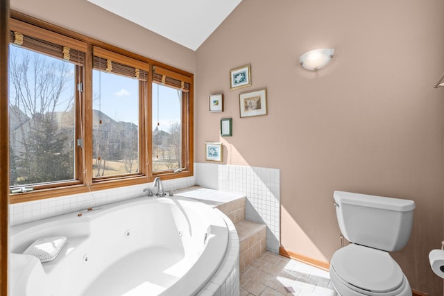 full bathroom featuring lofted ceiling, toilet, a tub with jets, and baseboards