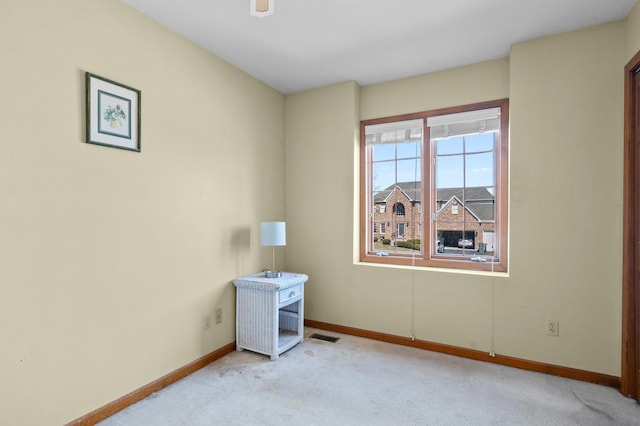 unfurnished room with light carpet, visible vents, and baseboards