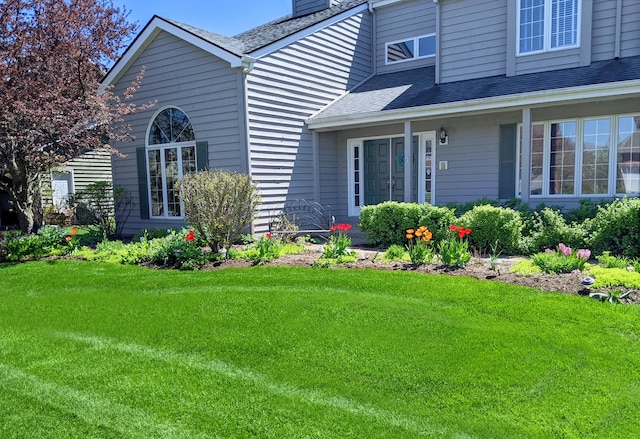 property entrance featuring a lawn and a chimney