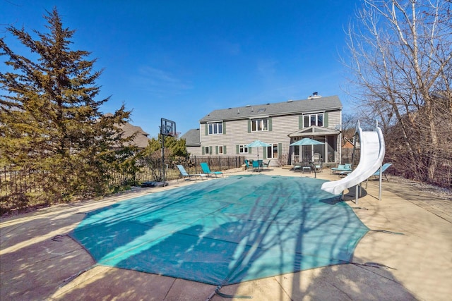 view of pool featuring a patio area, fence, and a water slide