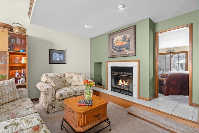 living room with a tile fireplace and baseboards