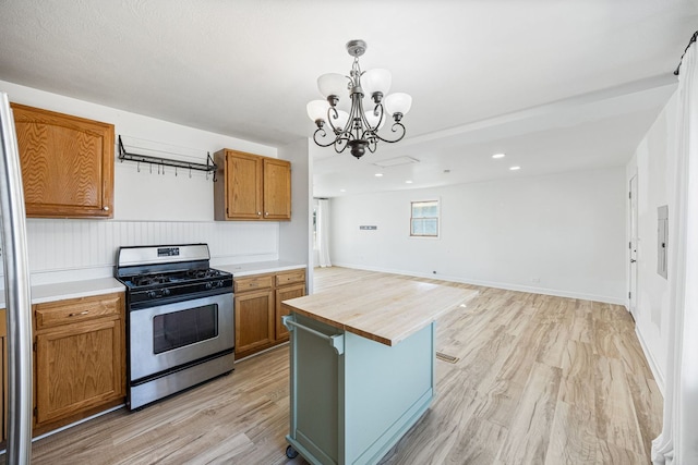 kitchen with wooden counters, stainless steel range with gas cooktop, open floor plan, light wood-style flooring, and brown cabinets