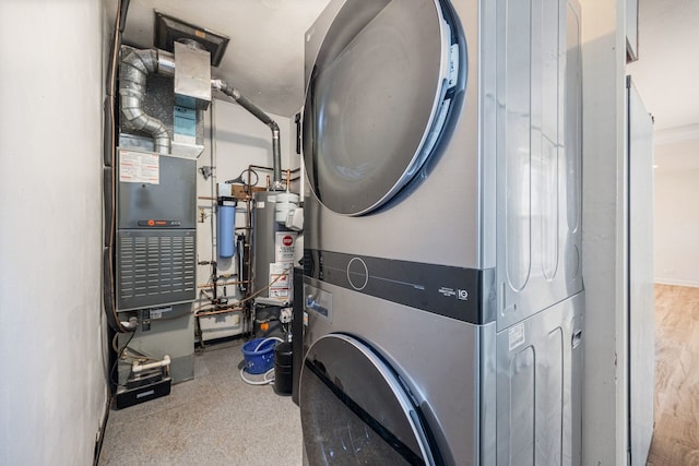 laundry room with water heater, laundry area, and stacked washer and clothes dryer