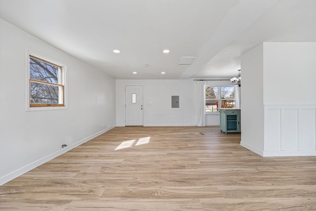 entryway featuring electric panel, a notable chandelier, light wood-style flooring, and recessed lighting