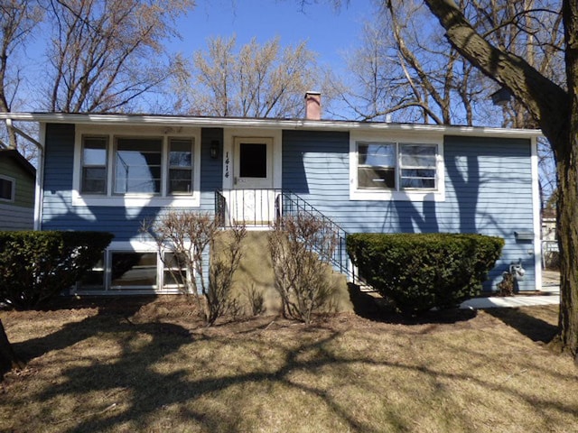 view of front of house with a chimney and a front yard