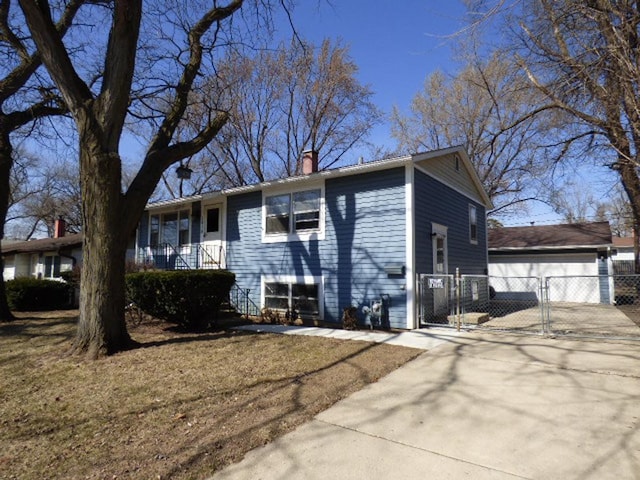 view of front of property featuring a gate, a garage, a chimney, and fence