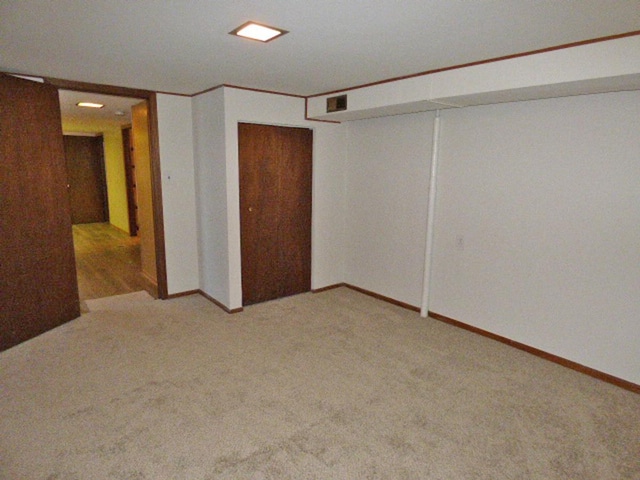 finished basement with visible vents, baseboards, and carpet