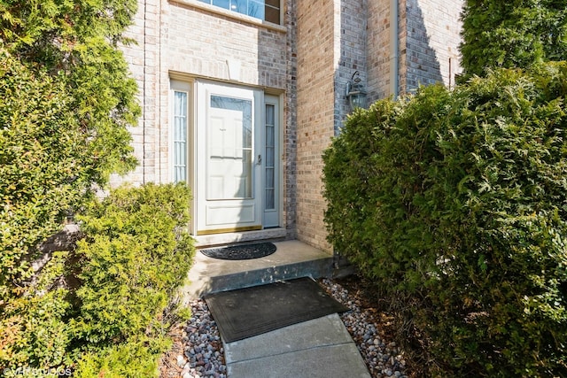 view of exterior entry with brick siding