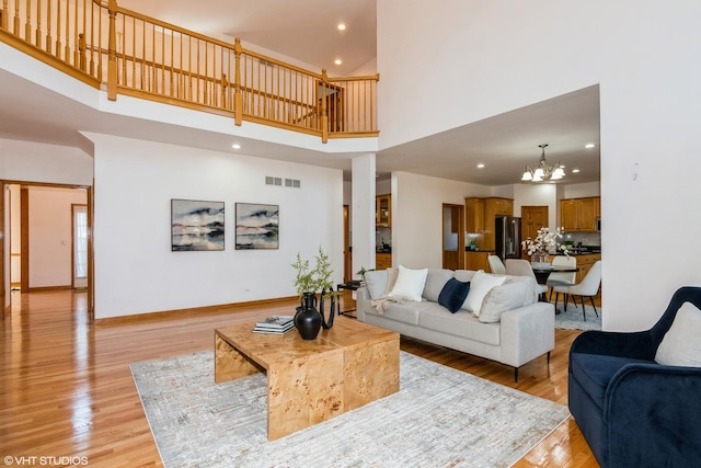 living area featuring visible vents, recessed lighting, light wood-style floors, an inviting chandelier, and baseboards