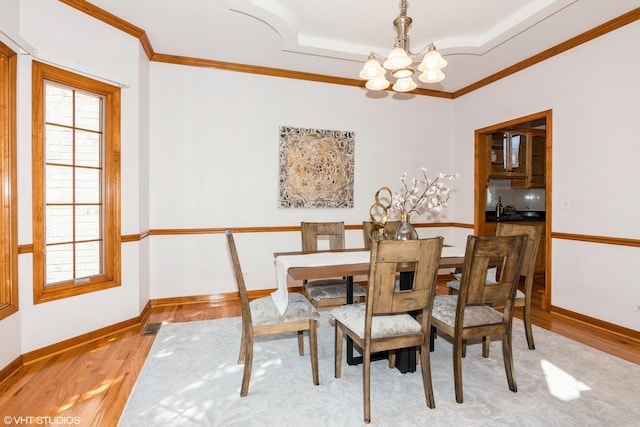 dining space featuring a wealth of natural light, a notable chandelier, light wood-style flooring, and crown molding