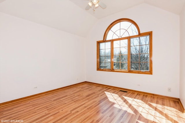 spare room with light wood finished floors, visible vents, ceiling fan, baseboards, and lofted ceiling