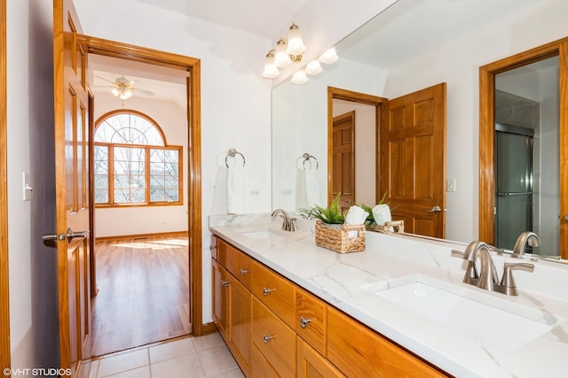 bathroom featuring double vanity, a shower with door, tile patterned floors, and a sink