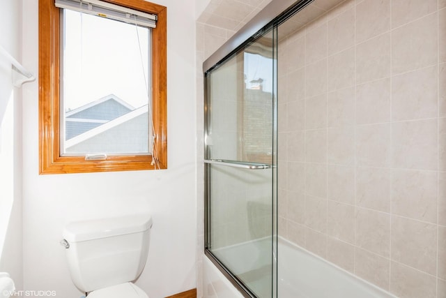 full bathroom featuring toilet and shower / bath combination with glass door