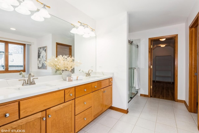 bathroom with tile patterned flooring, a stall shower, double vanity, and a sink