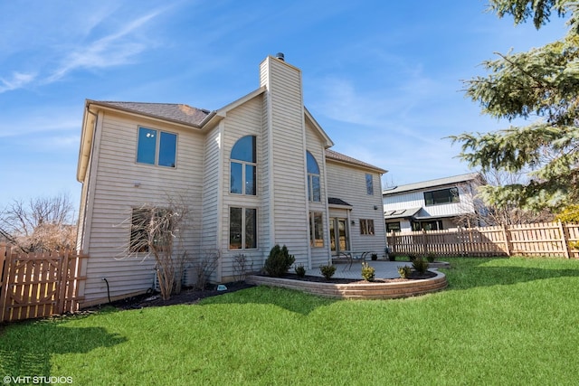 back of property featuring a patio, a chimney, a yard, and fence