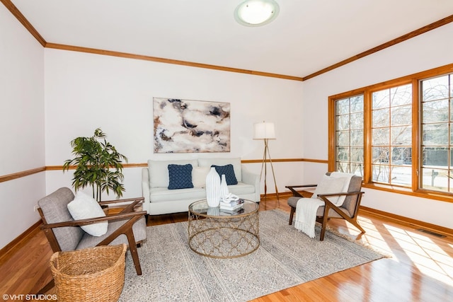 sitting room featuring visible vents, crown molding, baseboards, and wood finished floors