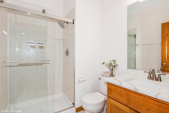 bathroom featuring vanity, toilet, and a shower stall