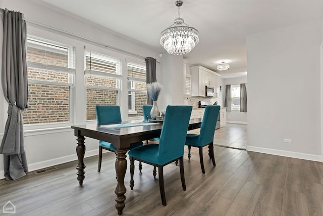 dining room with visible vents, baseboards, an inviting chandelier, and dark wood-style flooring