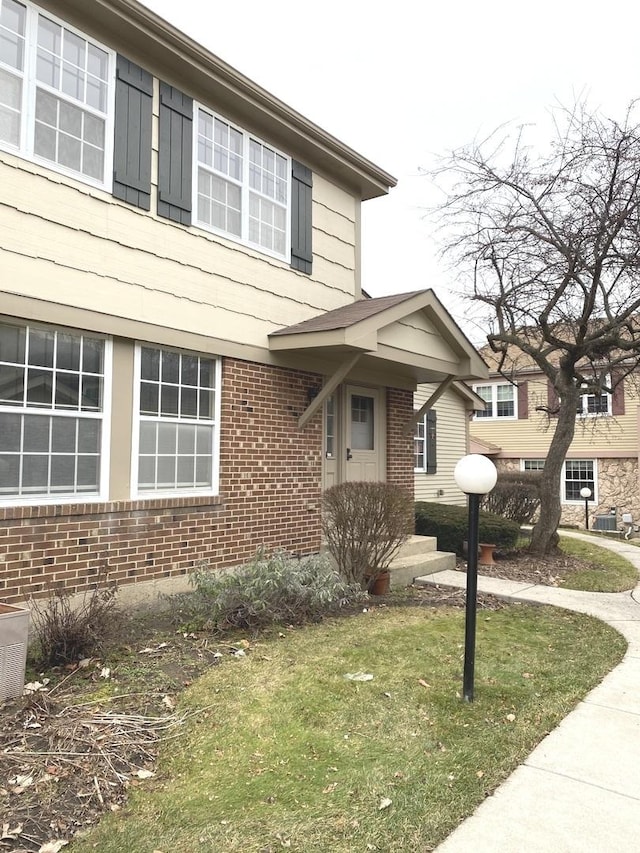 view of front of house featuring brick siding and a front yard