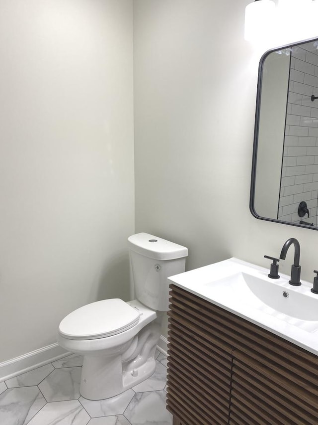 bathroom featuring marble finish floor, toilet, vanity, and baseboards