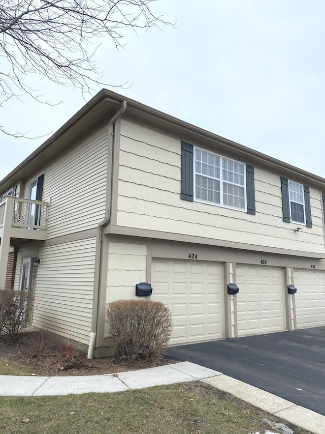 view of property exterior featuring aphalt driveway and an attached garage