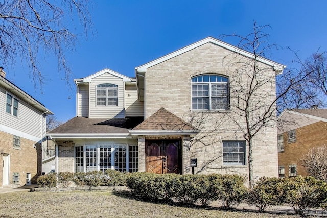 view of front of house with brick siding and a shingled roof