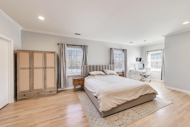 bedroom with multiple windows, light wood-type flooring, and baseboards