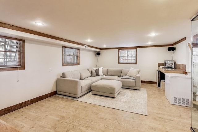 living room featuring recessed lighting, a healthy amount of sunlight, light wood-type flooring, and baseboards