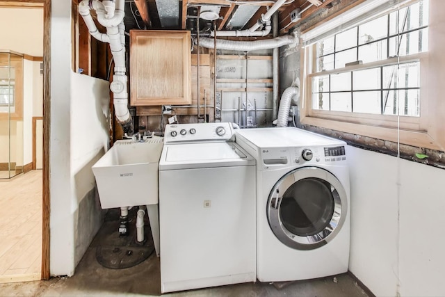 washroom with a sink and washing machine and clothes dryer