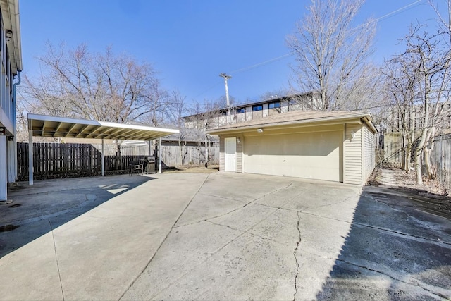 exterior space with a garage, an outdoor structure, and fence