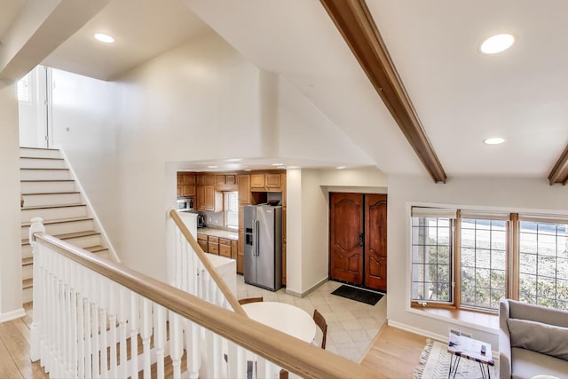 entryway featuring baseboards, recessed lighting, stairs, beamed ceiling, and light wood-type flooring