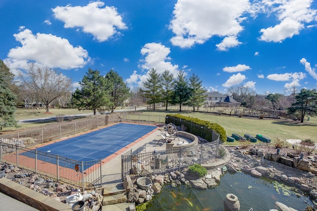 community pool featuring a patio, a lawn, and fence