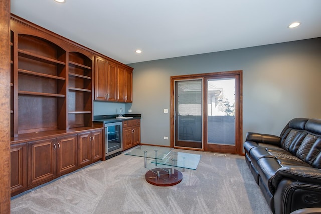 living area with beverage cooler, recessed lighting, light colored carpet, and wet bar